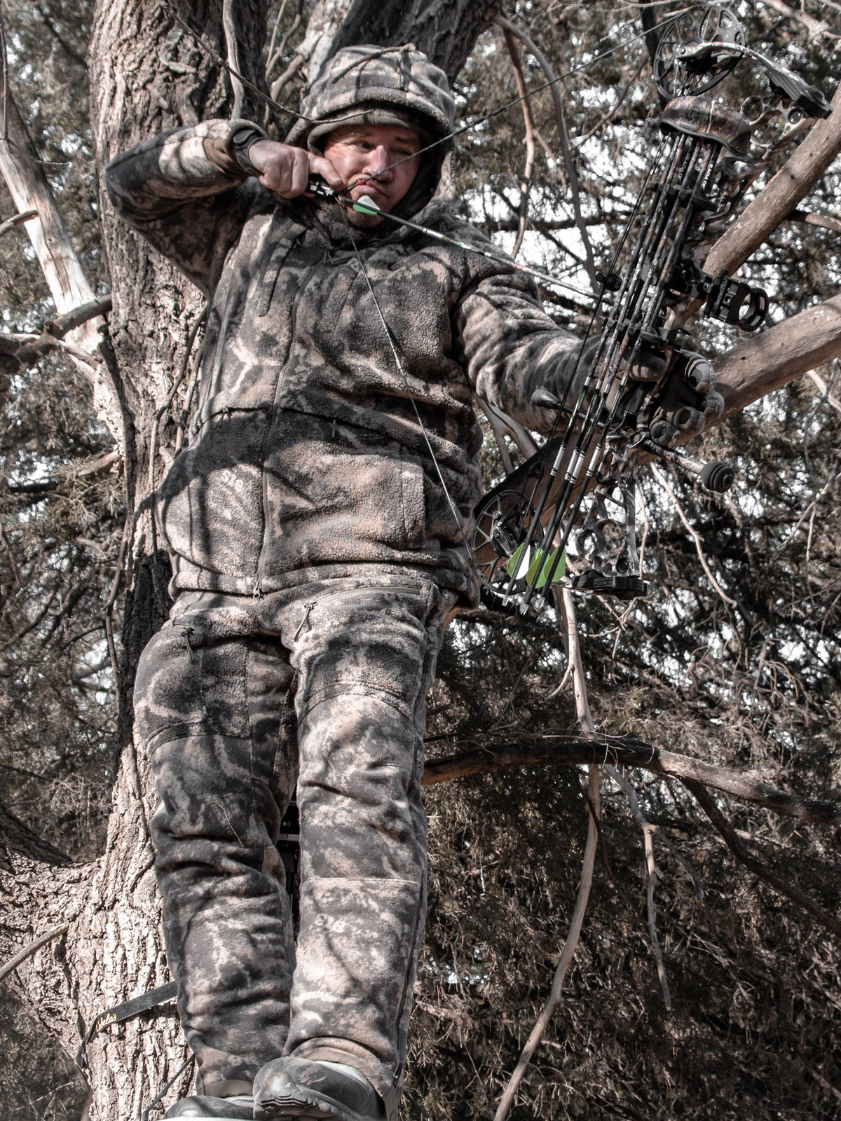 Hunter in a Code of Silence ColdFjall camo parka in the timber