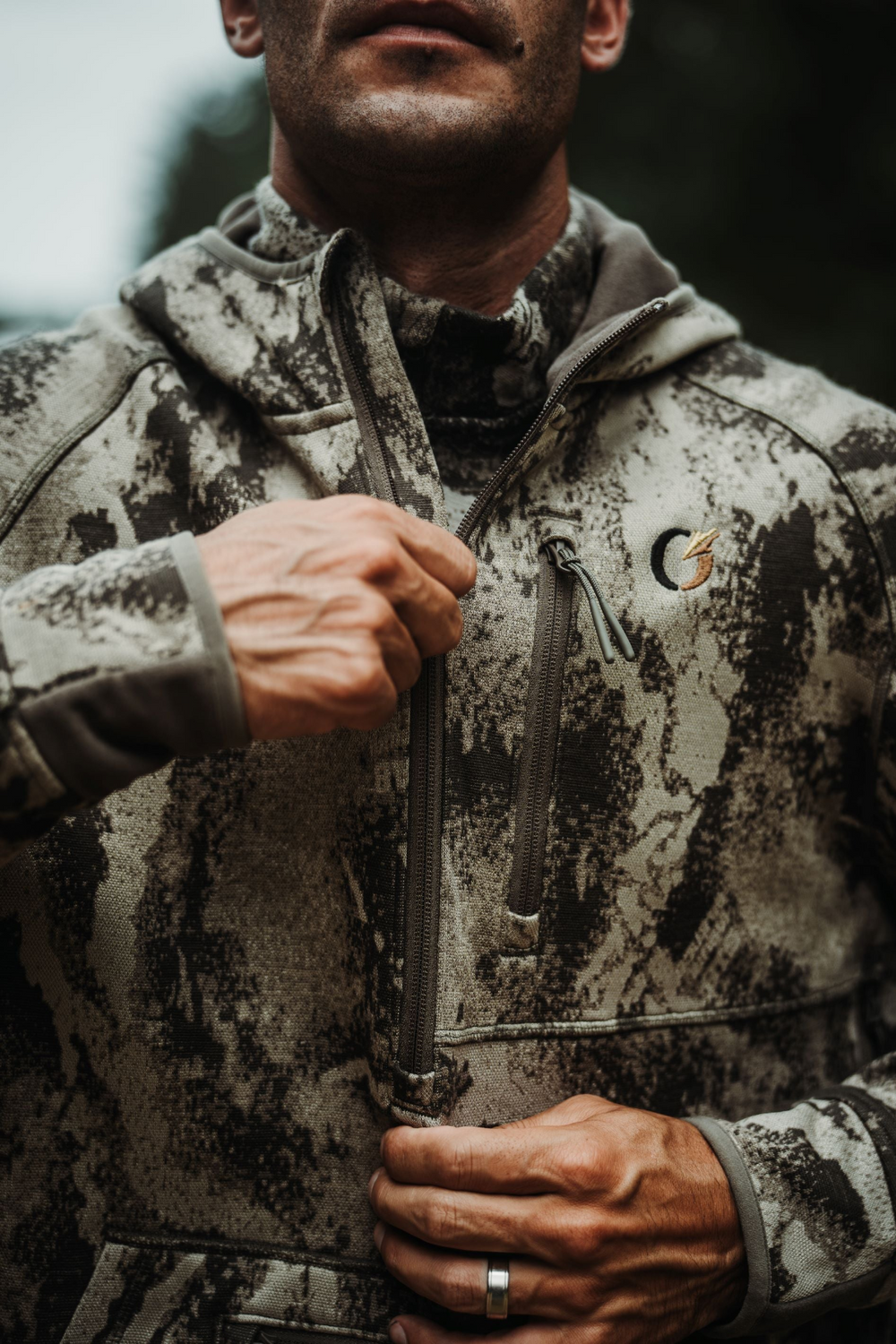 Hunter outdoors pulling up the quarter-zip on the FareWinds Merino FlexTec Hoodie.
